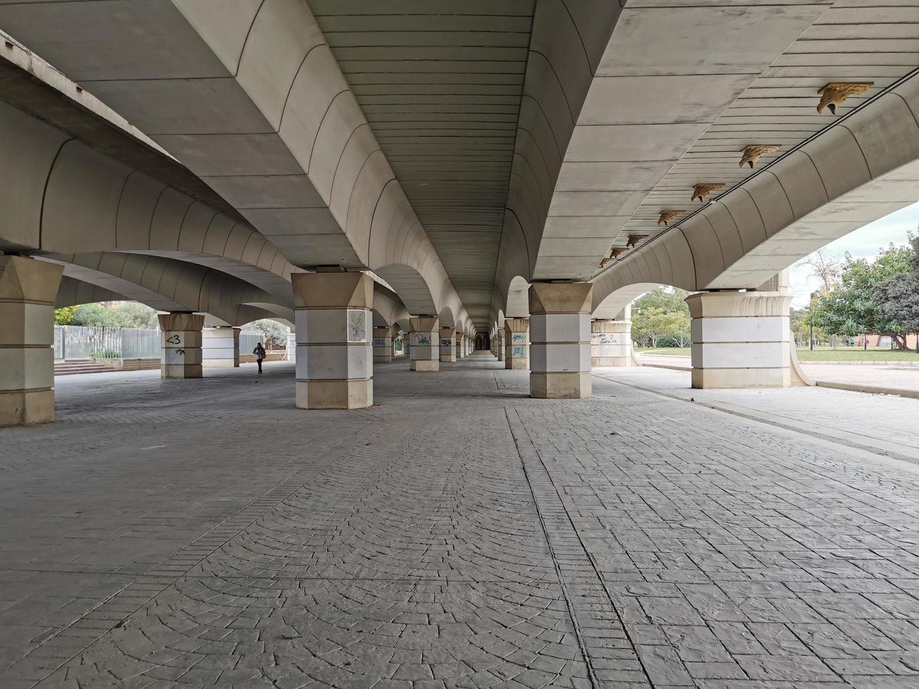 Somewhere under a beige wide bridge photo