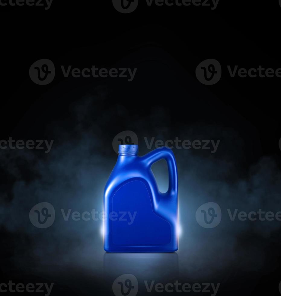 Blue bottle of engine oil on black background with smoke photo