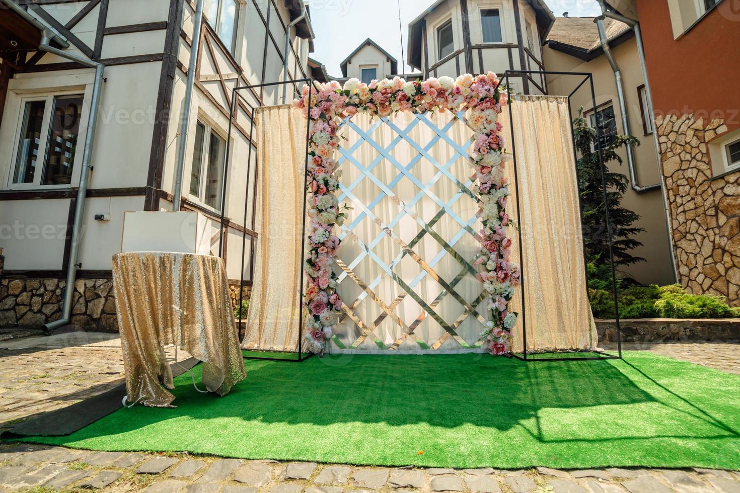 Boda decoración. el Boda ceremonia zona en el patio interior es decorado con blanco y rosado flores preparativos y oro paño foto