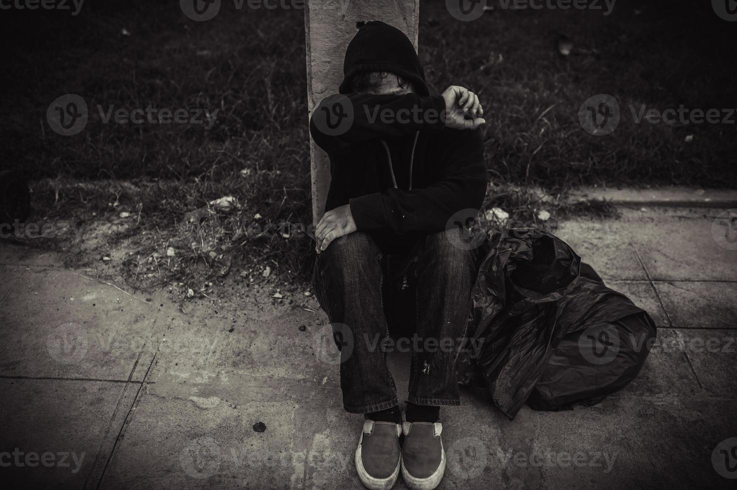 Asian man is homeless at the side road,A stranger has to live on the road alone because he has no family. photo