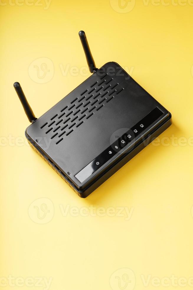 Wi-Fi router in black on a yellow background with free space. photo