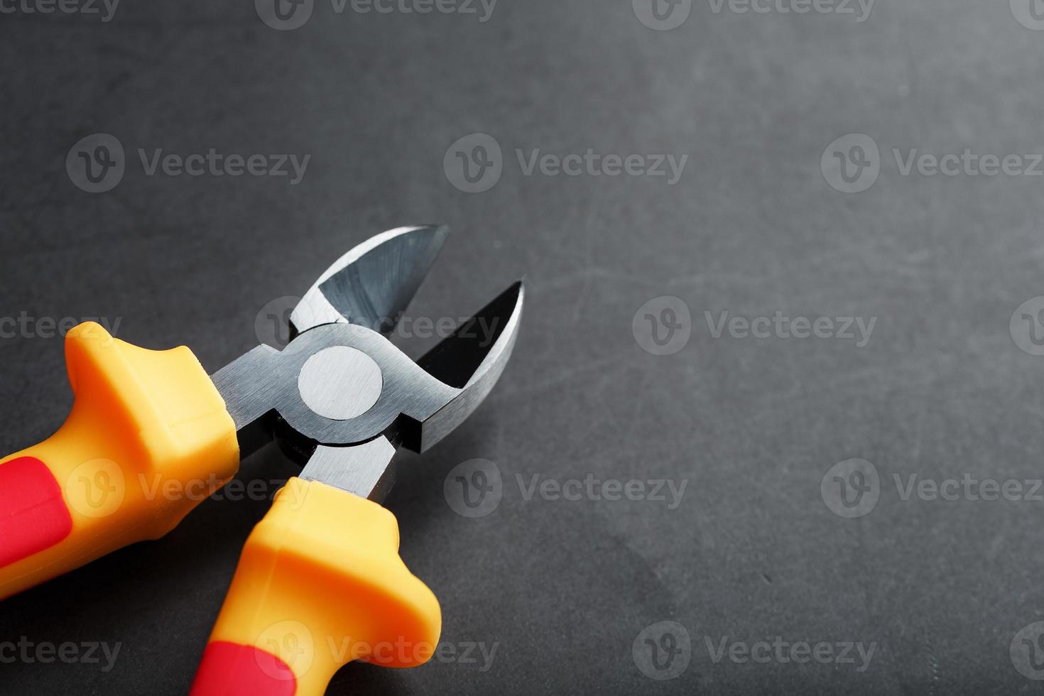 The pliers tool is red on a black background with a free space photo