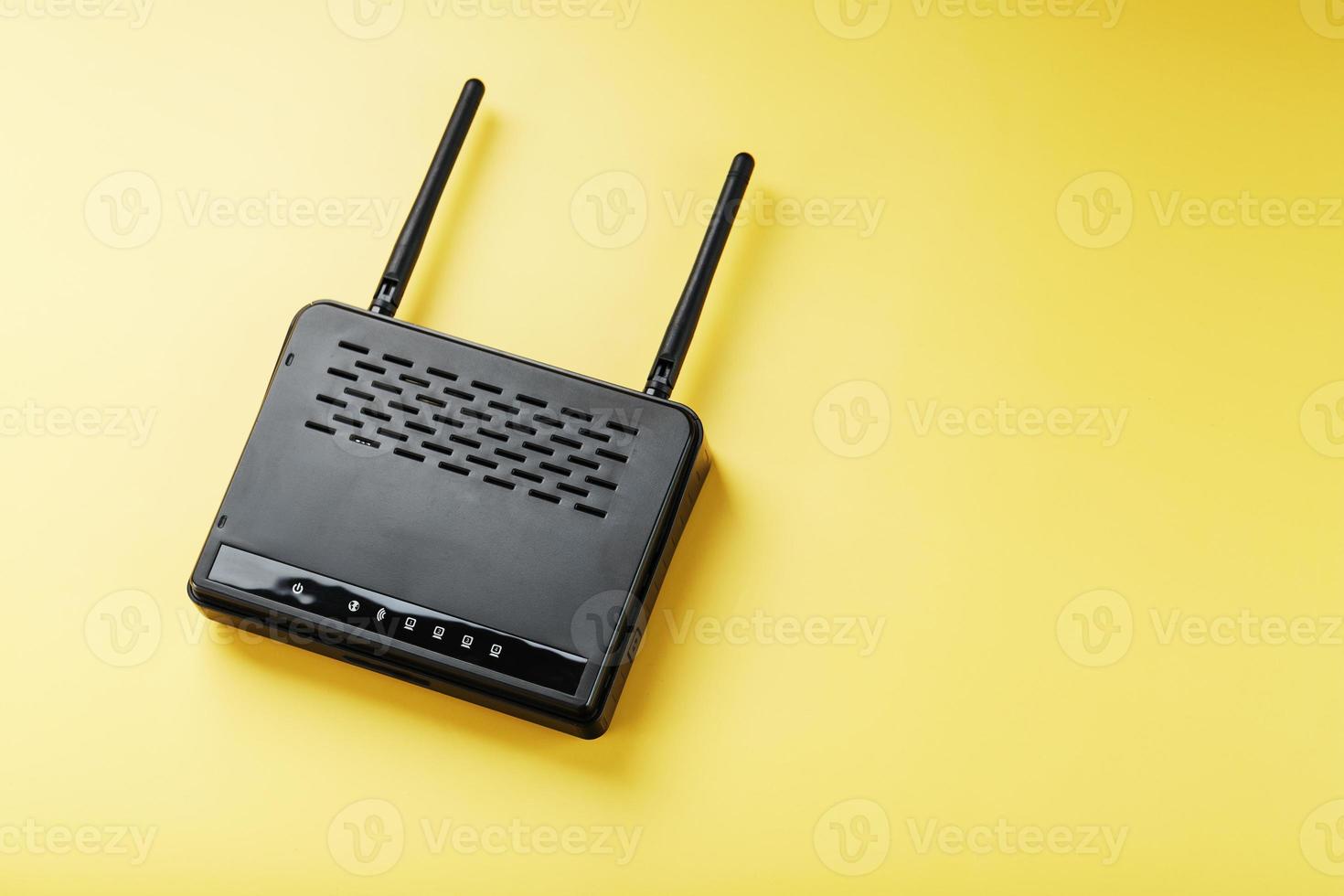 Wi-Fi router in black on a yellow background with free space. photo