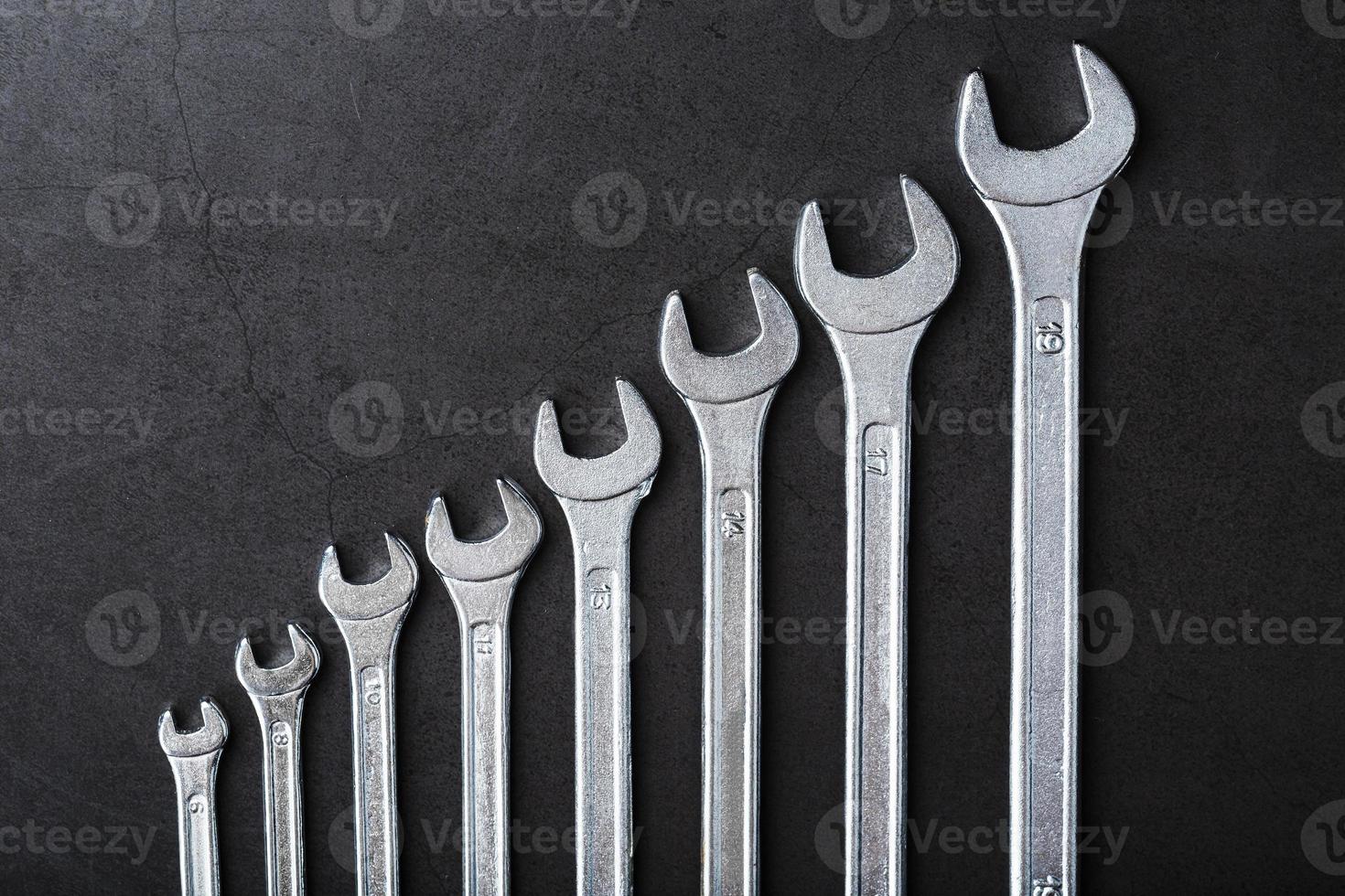 A set of wrenches in a row on a black background in a row. photo