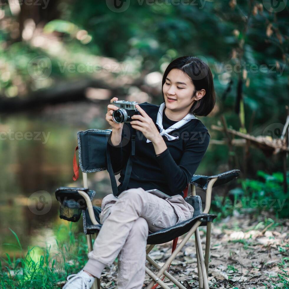 Young pretty woman use camera taking photo in nature park