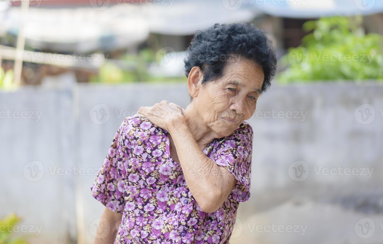 Sick senior adult elderly women touching the neck have shoulder and neck pain. Woman massaging her aching areas. Mature woman with joint problems. Healthcare and medicine concept photo