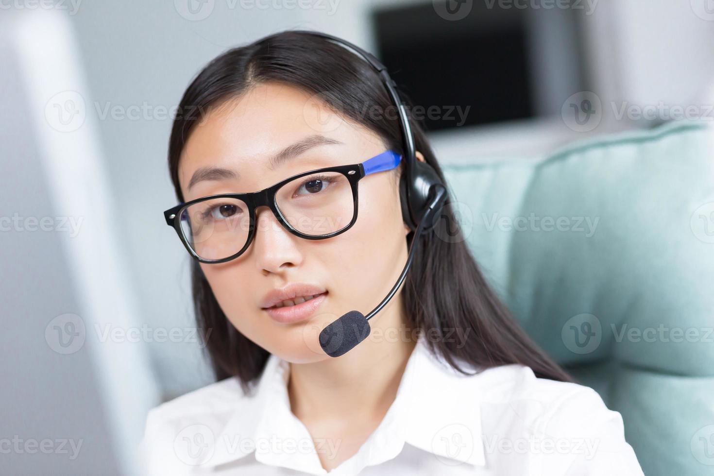 Close-up portrait photo of Asian female call center worker and tech support worker