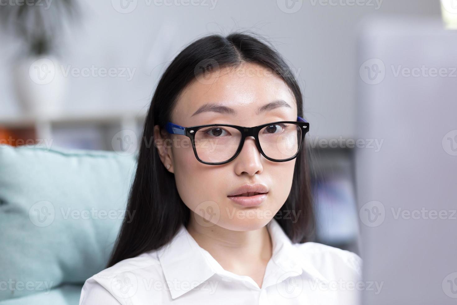 de cerca foto. retrato de un joven hermosa asiático mujer en el oficina. mujer de negocios, director foto