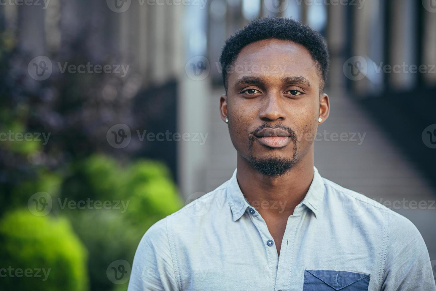 retrato de un joven grave africano americano hombre mirando a el cámara, grave foto