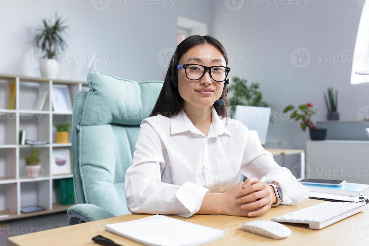 Young tech support worker, portrait Asian business woman working in modern office photo