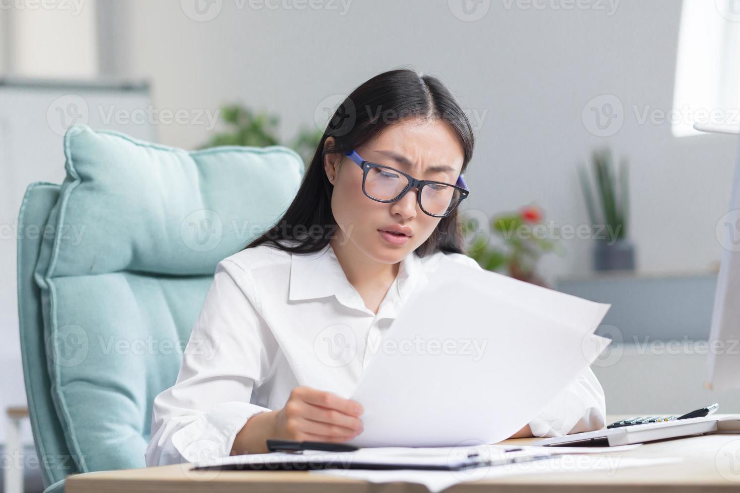 asiático negocio mujer detrás papel trabajar, cansado y frustrado, trabajando en oficina foto