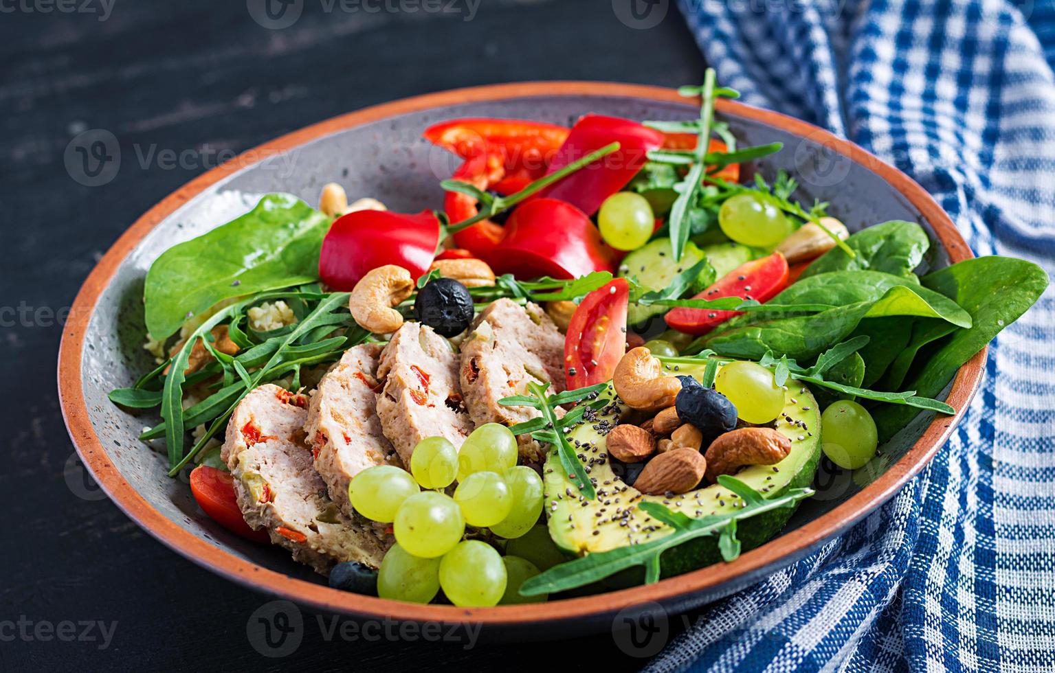 Ketogenic diet. Buddha bowl dish with meatloaf, avocado, sweet pepper, tomato, cucumber, berries and nuts. Detox and healthy superfoods bowl concept. photo