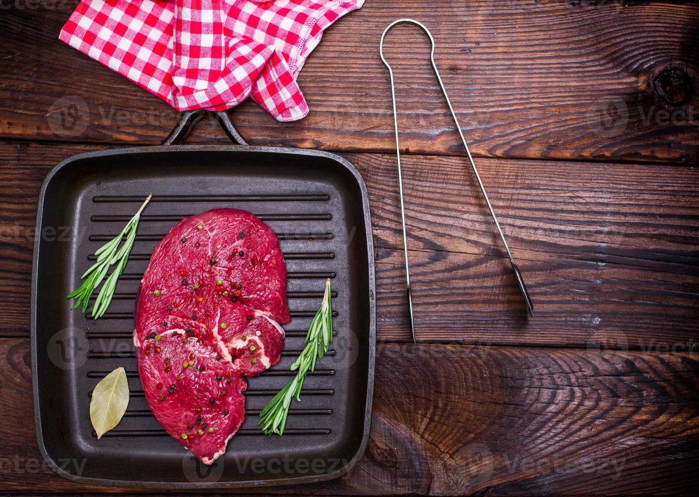 raw beef steak on a black quart pan photo