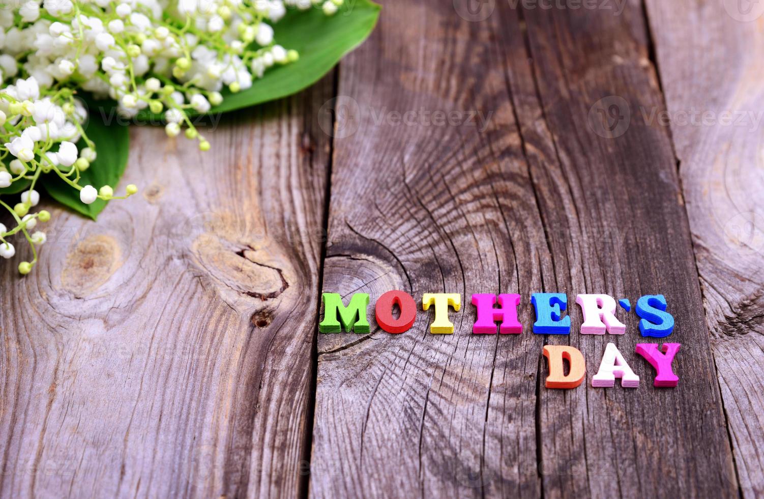 Gray wooden background with the inscription Mother's Day photo