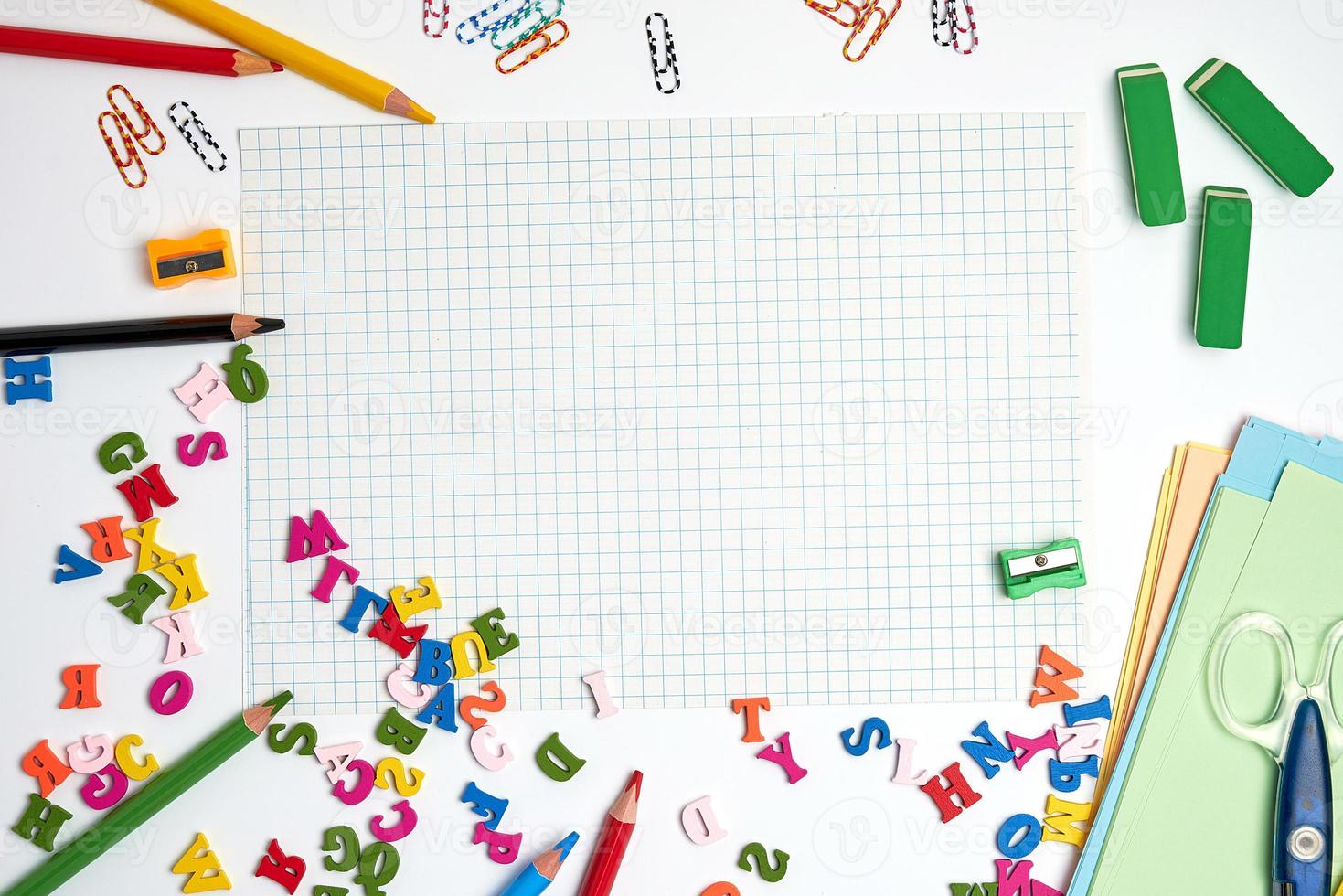 school supplies multicolored wooden pencils,  notebook, colored paper and  blank white sheet photo