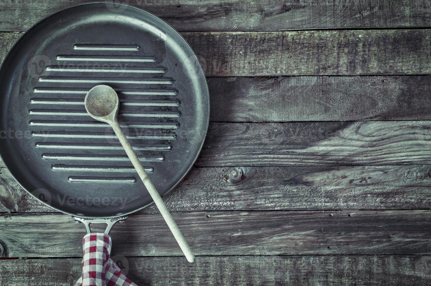 negro parrilla pan en un marrón de madera superficie foto