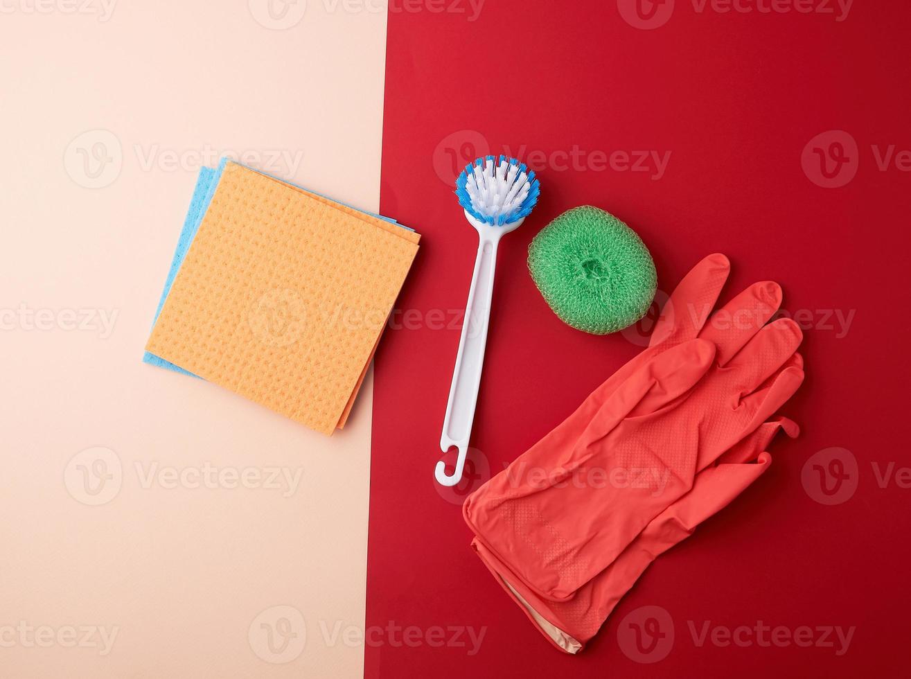 items for home cleaning red rubber gloves, brush, multi-colored sponges photo