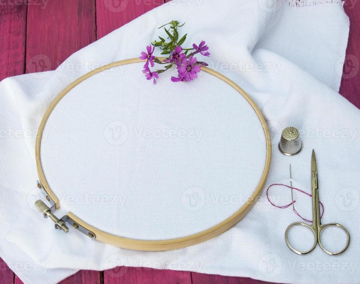 white fabric for embroidery in wooden round embroidery frame photo