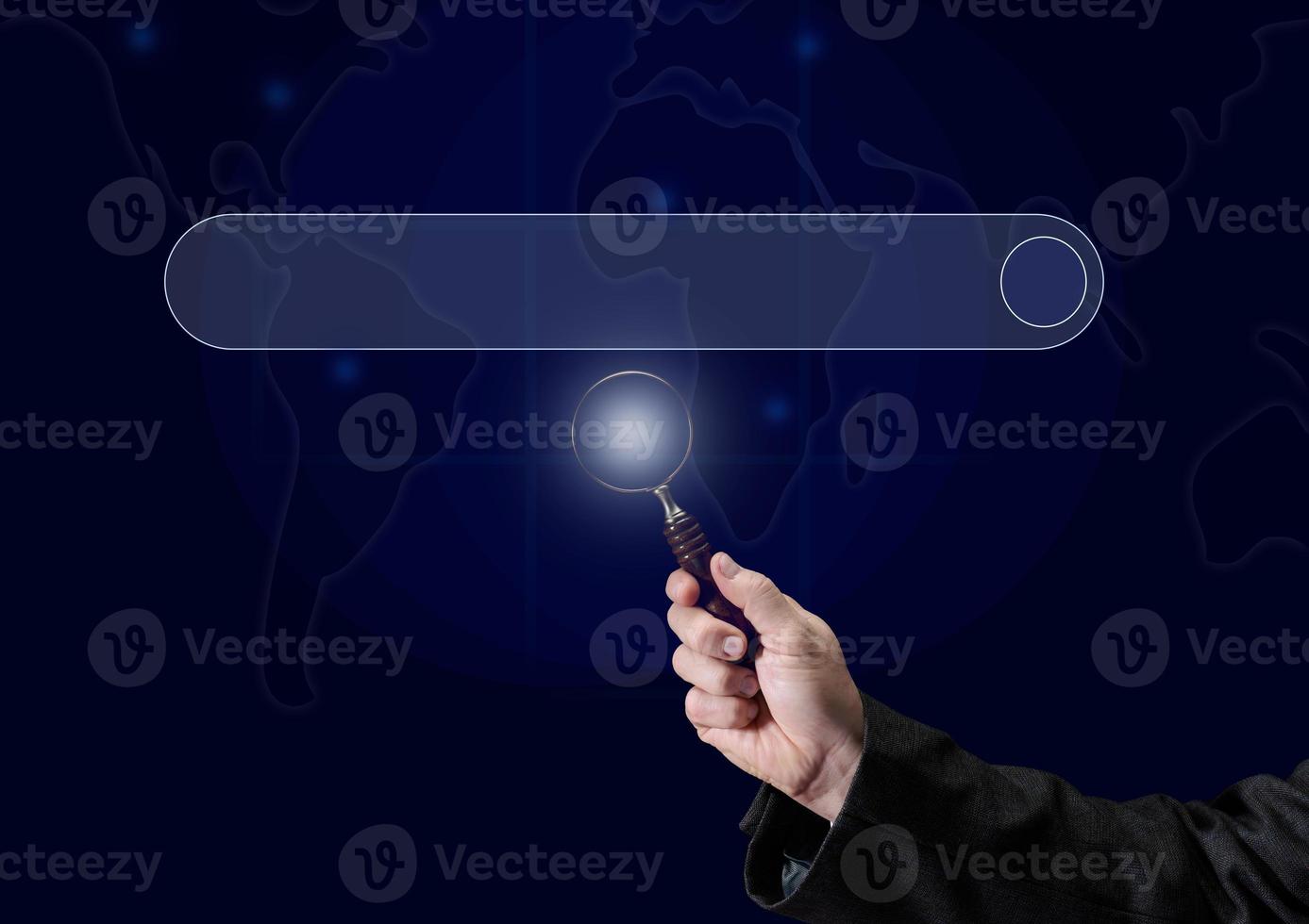 a man's hand holds a magnifying glass on the background of a template for entering and searching information on the Internet. Globalization, availability of information photo