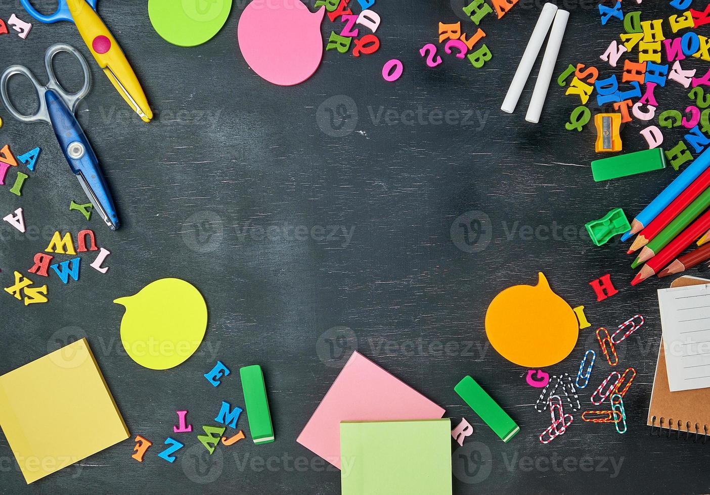 school supplies multicolored wooden pencils, notebook, paper stickers, paper clips photo