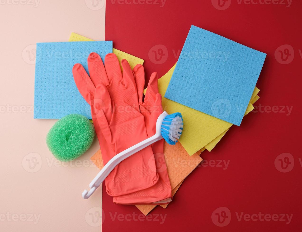items for home cleaning red rubber gloves, brush, multi-colored sponges photo