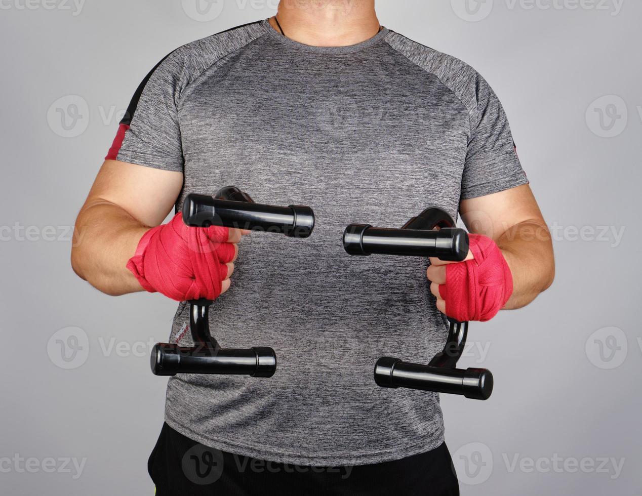adult athlete in a gray t-shirt is standing and holding a sports simulator photo
