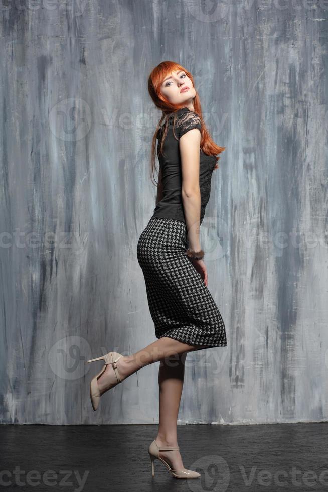 Young nice redhead lady posing in studio photo