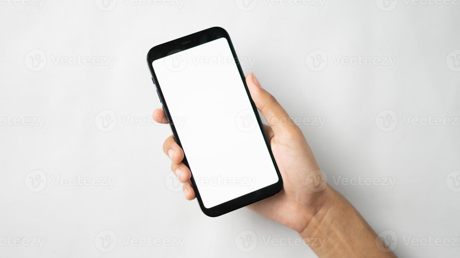 Hand holding blank screen smartphone isolated photo