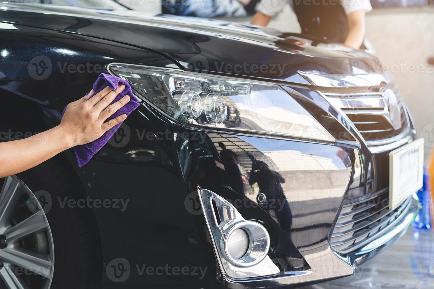 Close up hands of person using microfiber cloth wipe a car after wash the dust and prepare to polish wax. photo