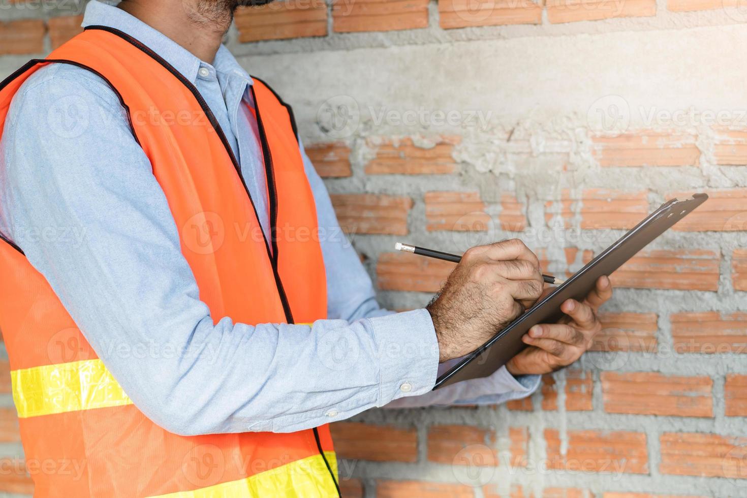 Asian inspector checking structure of new property and taking note in the clipboard for review and fix the house before sell to client photo