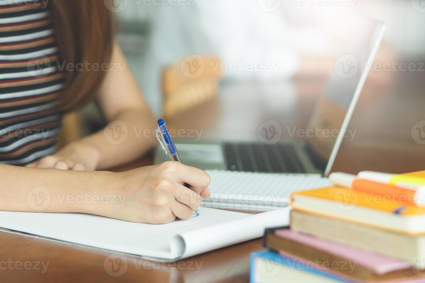 female asian student studying and reading book in library photo