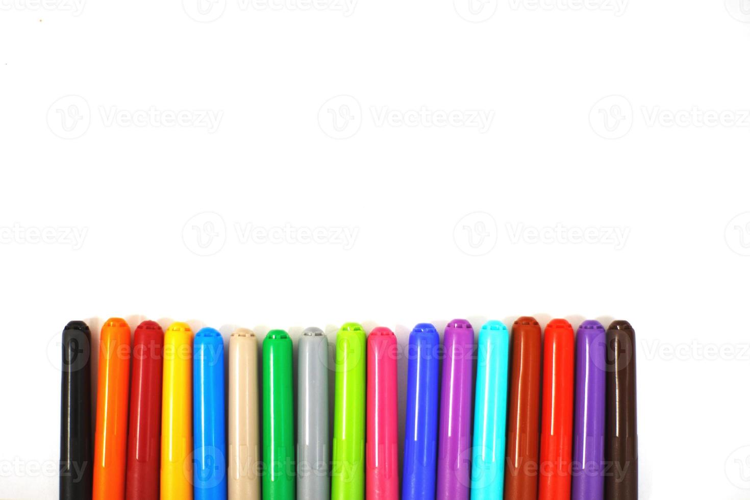 multi-colored felt-tip pens on a white sheet of paper. felt-tip pens on a white background photo