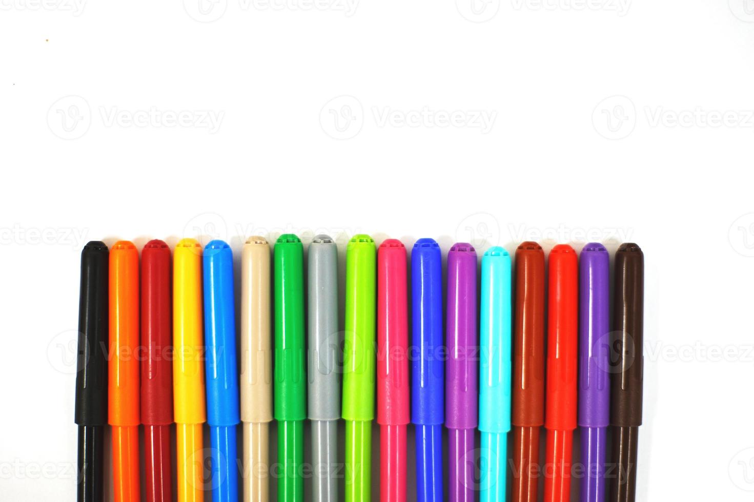 multi-colored felt-tip pens on a white sheet of paper. felt-tip pens on a white background photo