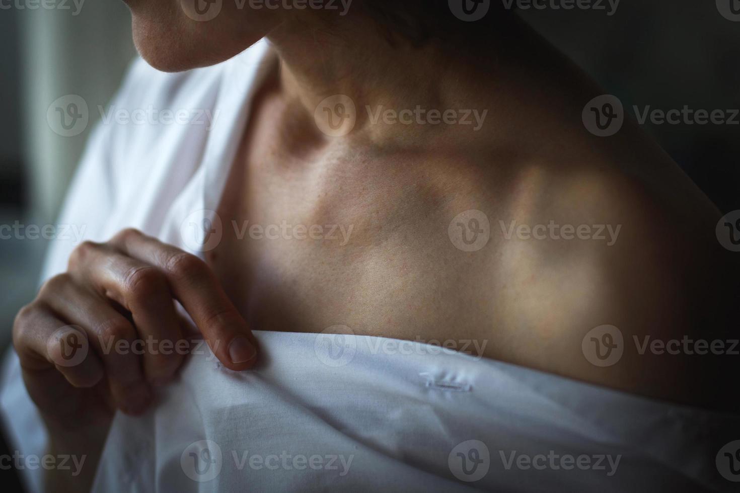 Sensual close up portrait of beautiful young lady relaxing at the window. female shoulder close up. hard shadows photo