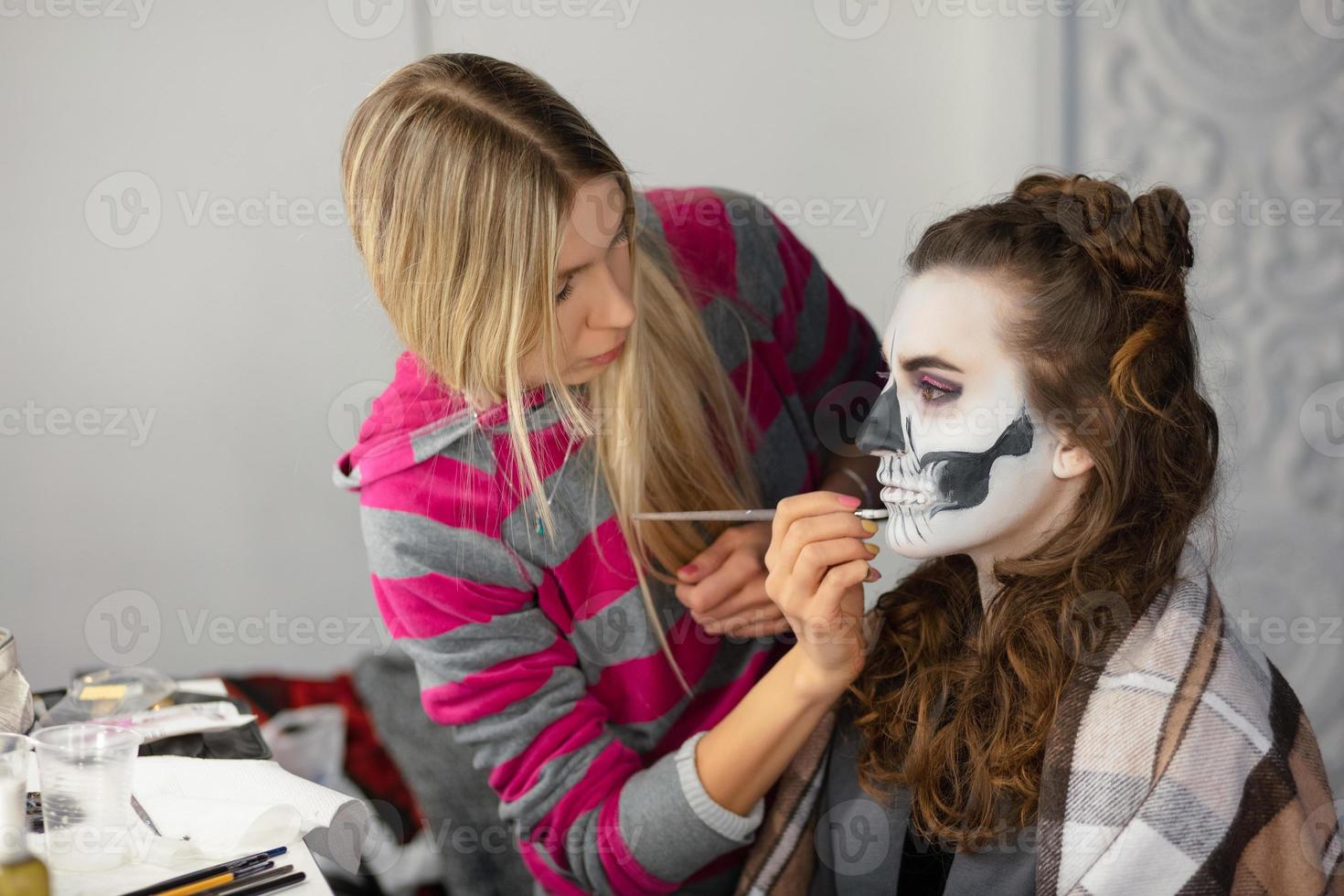Makeup artist puts body art of a nice model photo