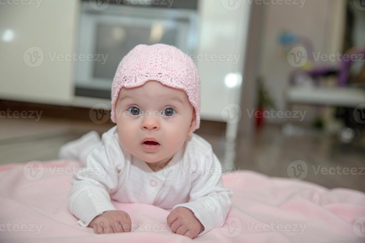 Cute little baby lies on a pink plaid photo