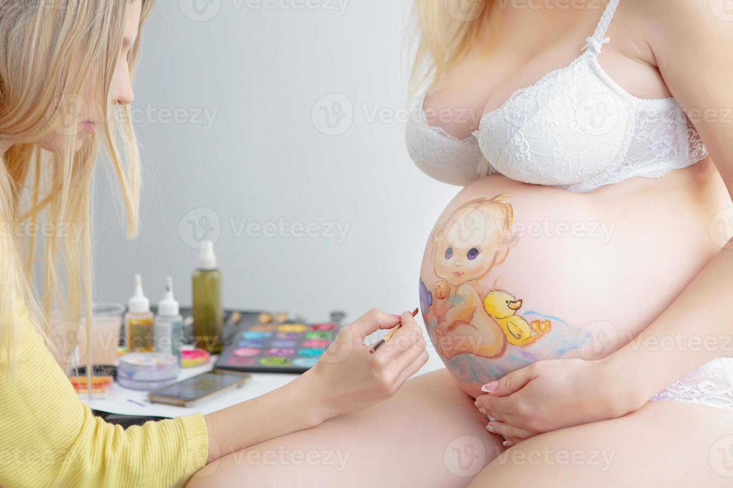 maquillaje artista sorteos un linda bebé en el barriga de un embarazada joven mujer foto