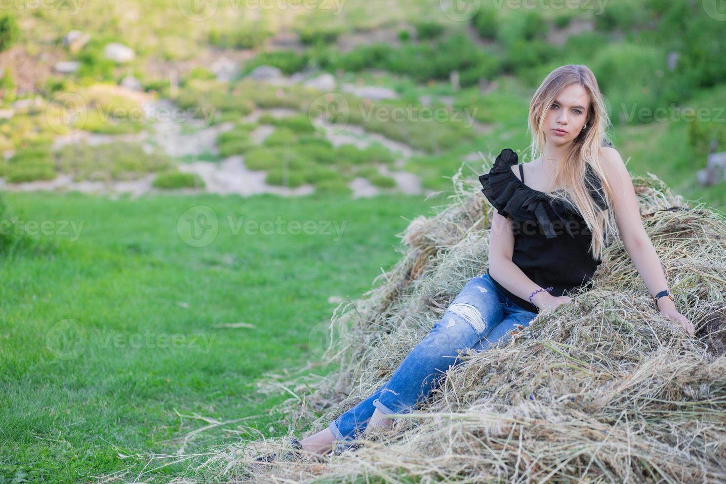 Alluring lady posing sitting on the hay photo