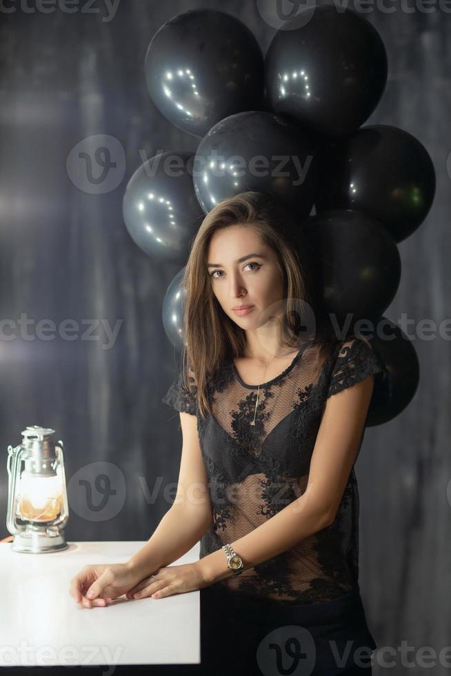 Pretty young brunette posing near a table photo