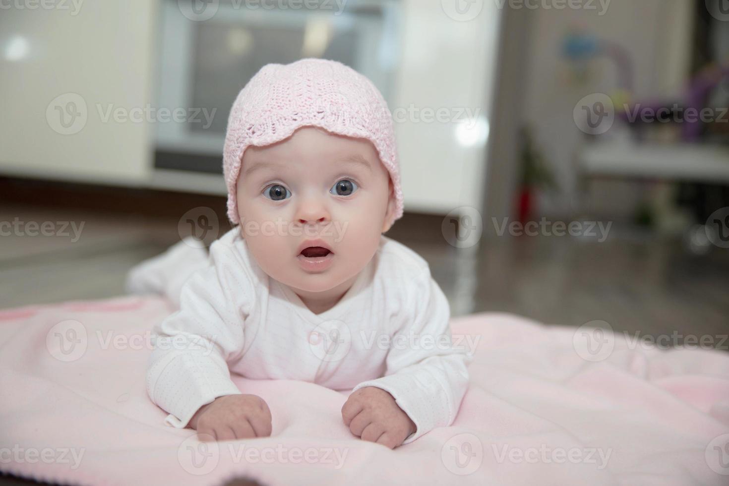 Pretty little baby lies on a pink plaid photo