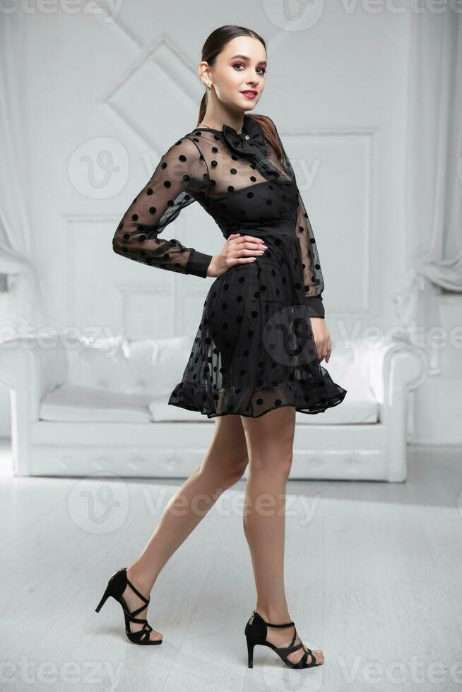 Beautiful brunette model wearing a black dress photo