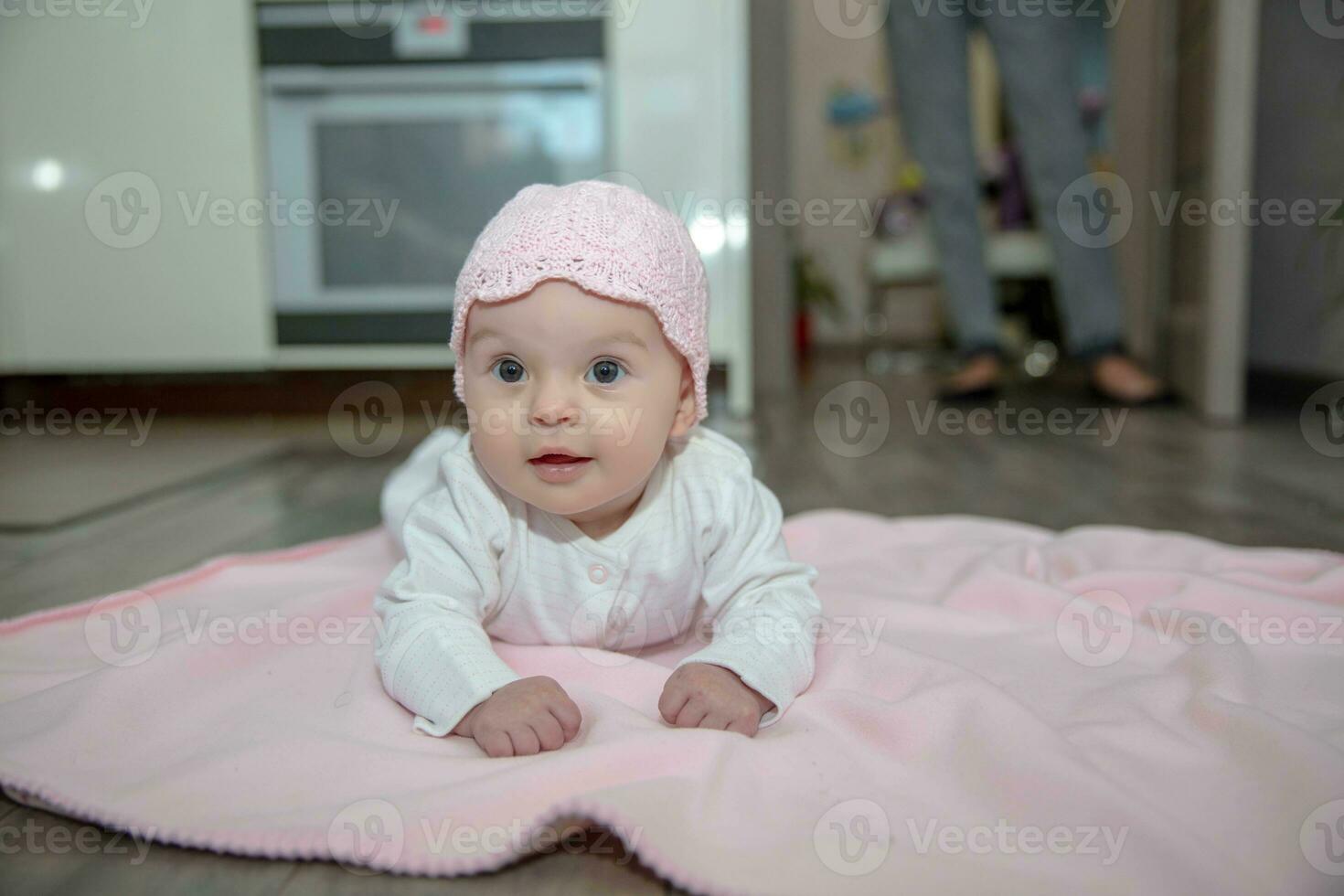 Beautiful little baby lies on a pink plaid photo