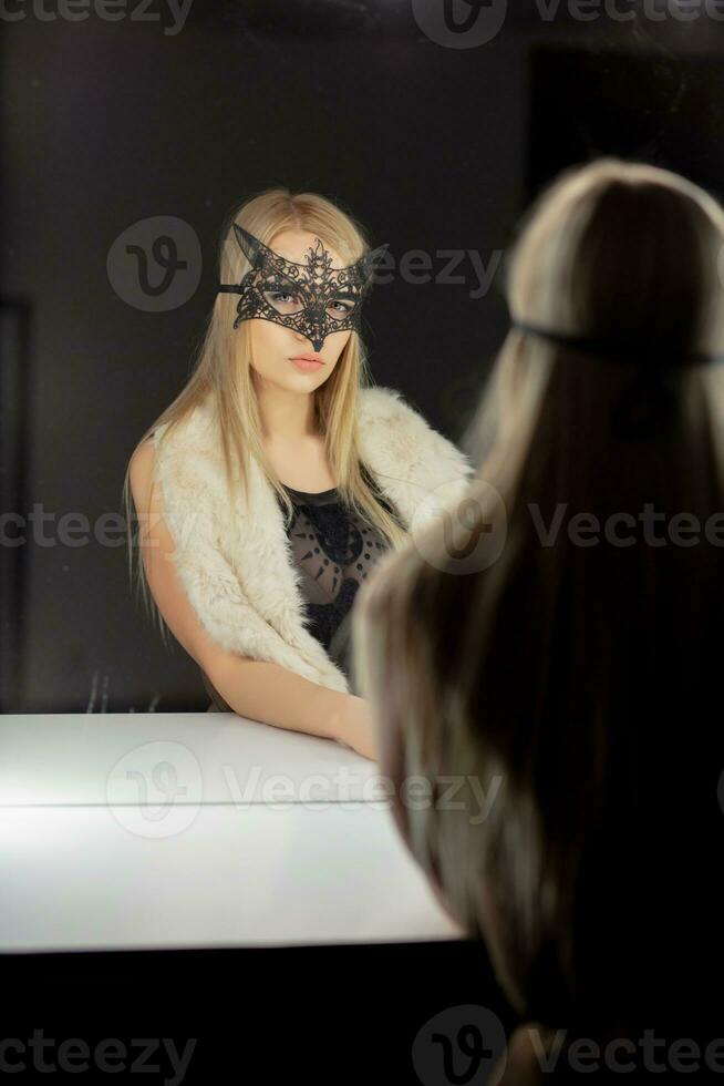 Reflection alluring young woman in a mask photo