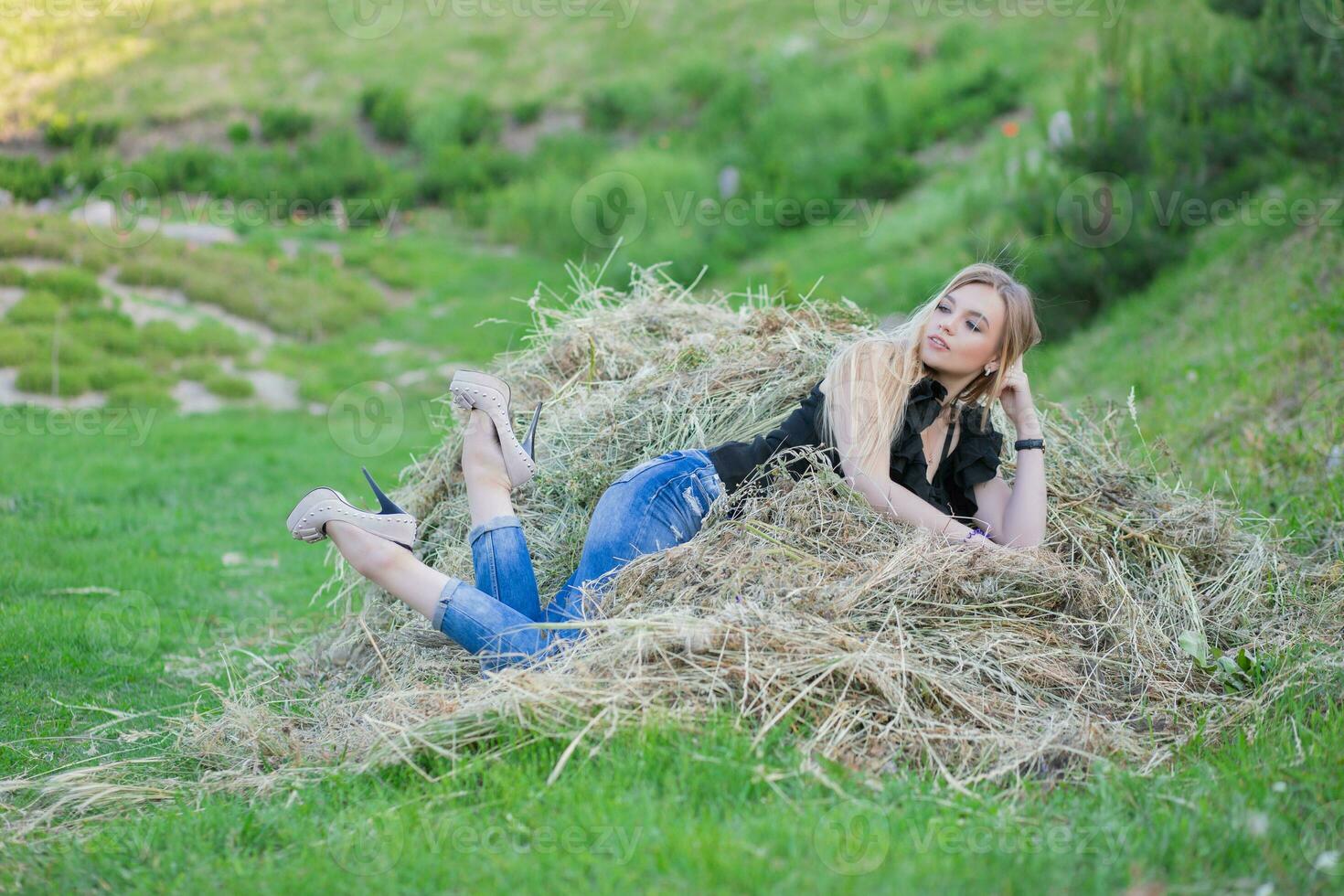 Lovely woman posing sitting on the hay photo