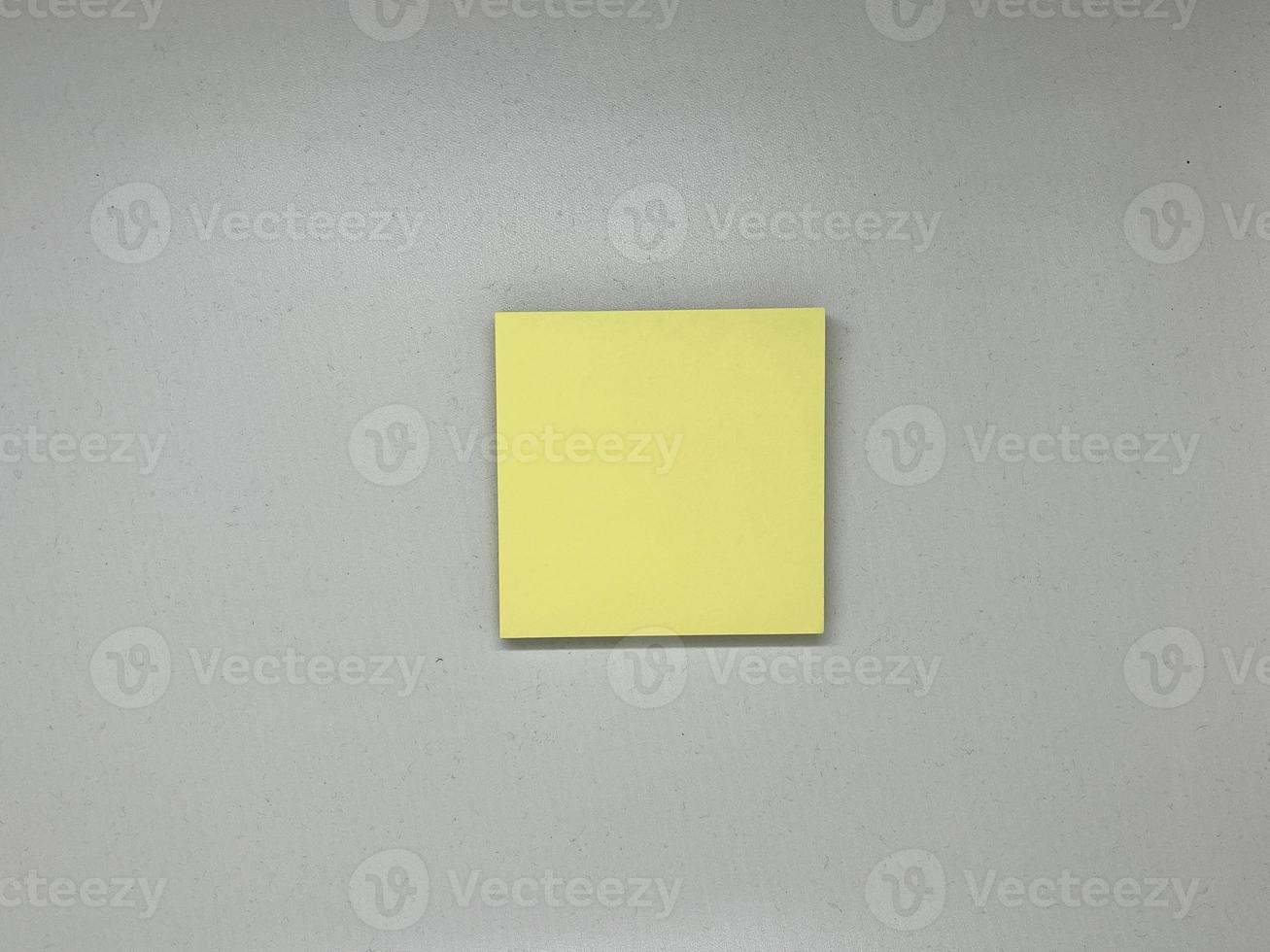 Yellow sticky note block on gray background photo