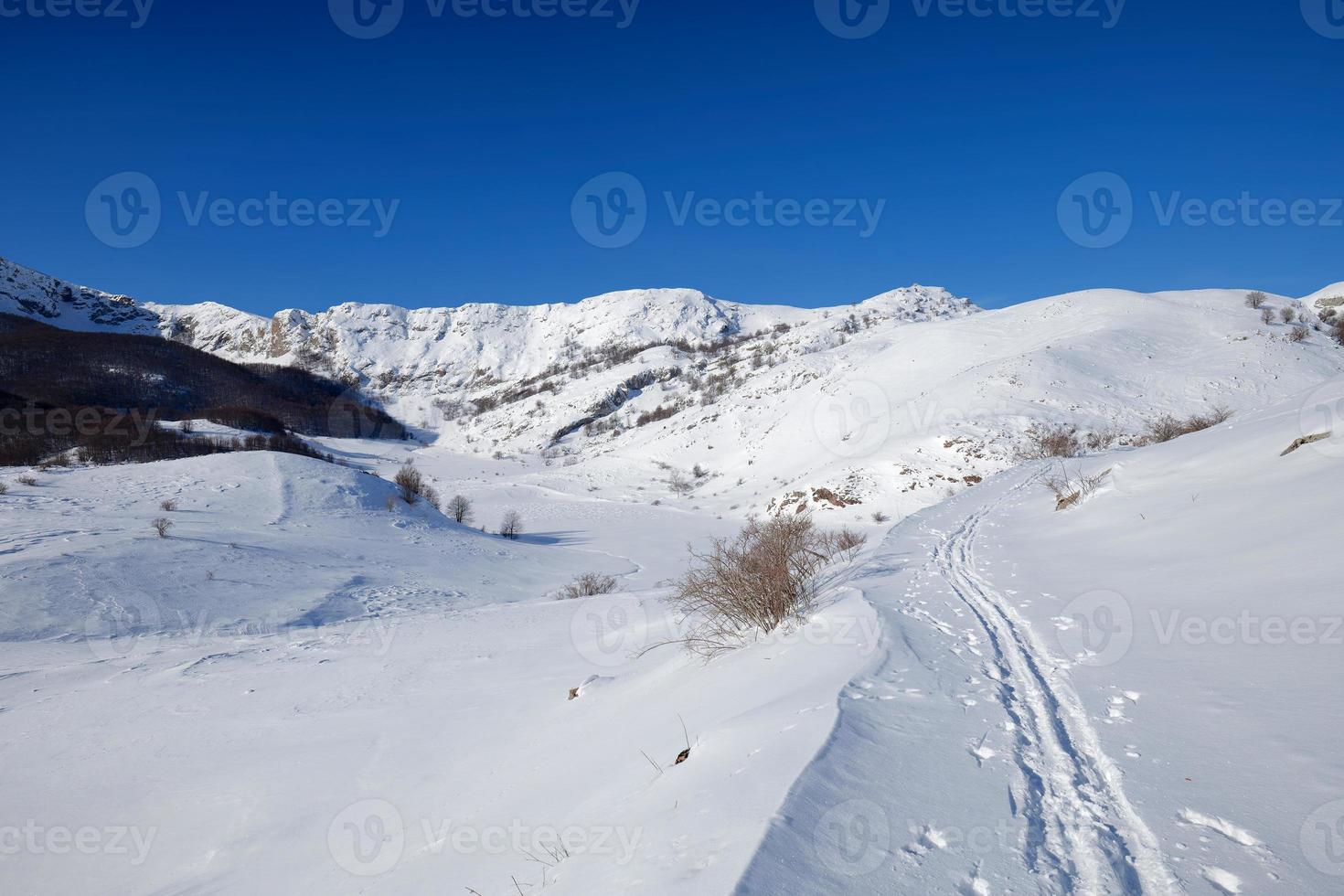 View of winter snow landscape in the mountains with a path made by mountaineers. Hiking lyfestile. Copy paste and blank space. photo