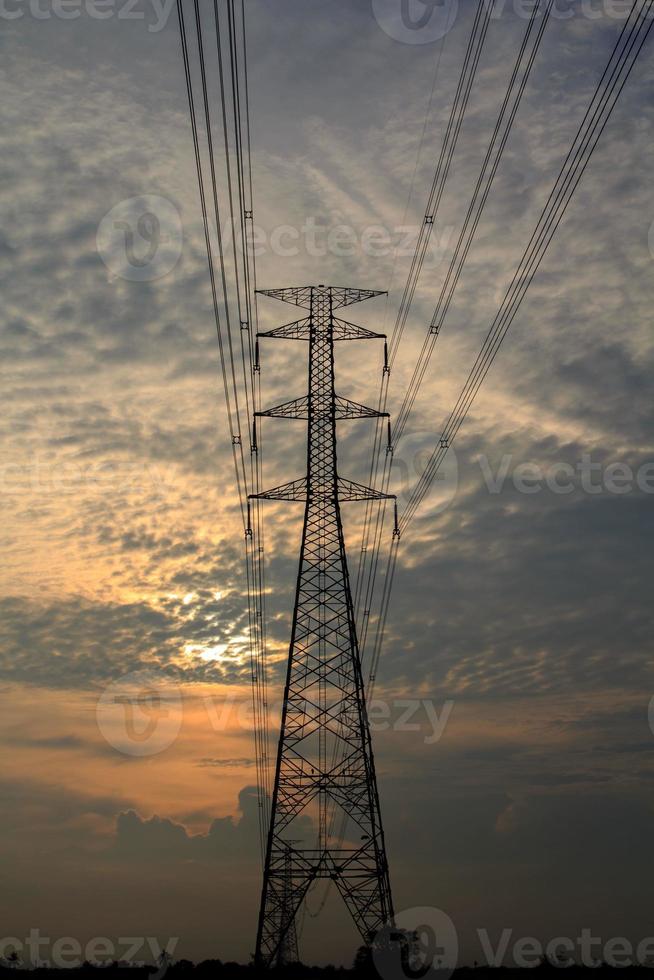 High-voltage poles are used to carry electricity for industrial plants and people to use in the farmer's fields in the evening. Beautiful sky atmosphere and designed by electrical engineers. photo