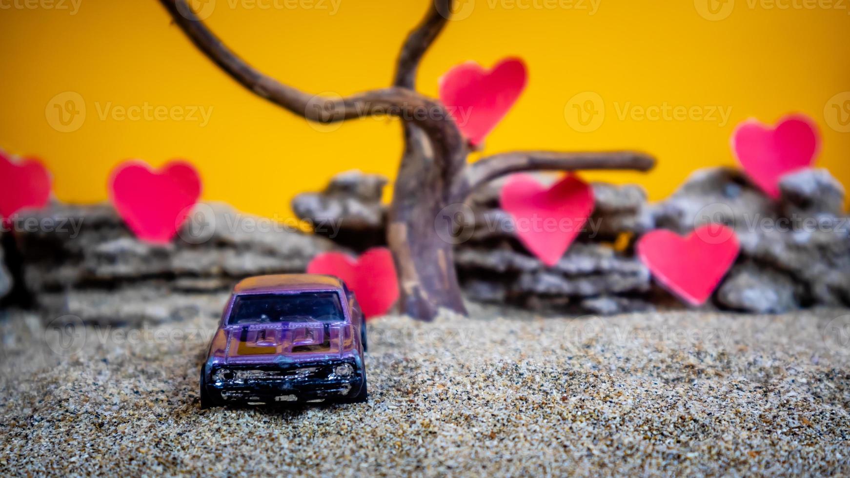 Minahasa, Indonesia  December 2022, toy car with gradient orange background and a heart photo