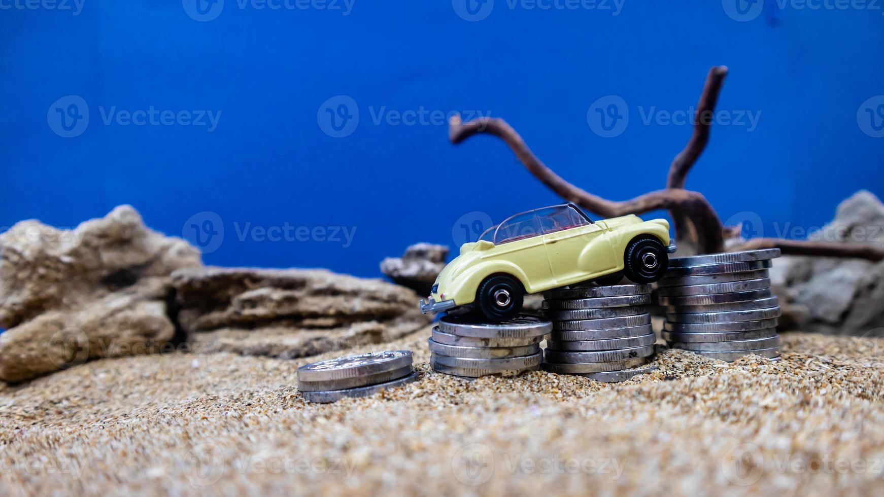 minahasa, Indonesia  January 2023, toy car on a pile of coins, saving for the future, managing successful transportation business technology concept photo