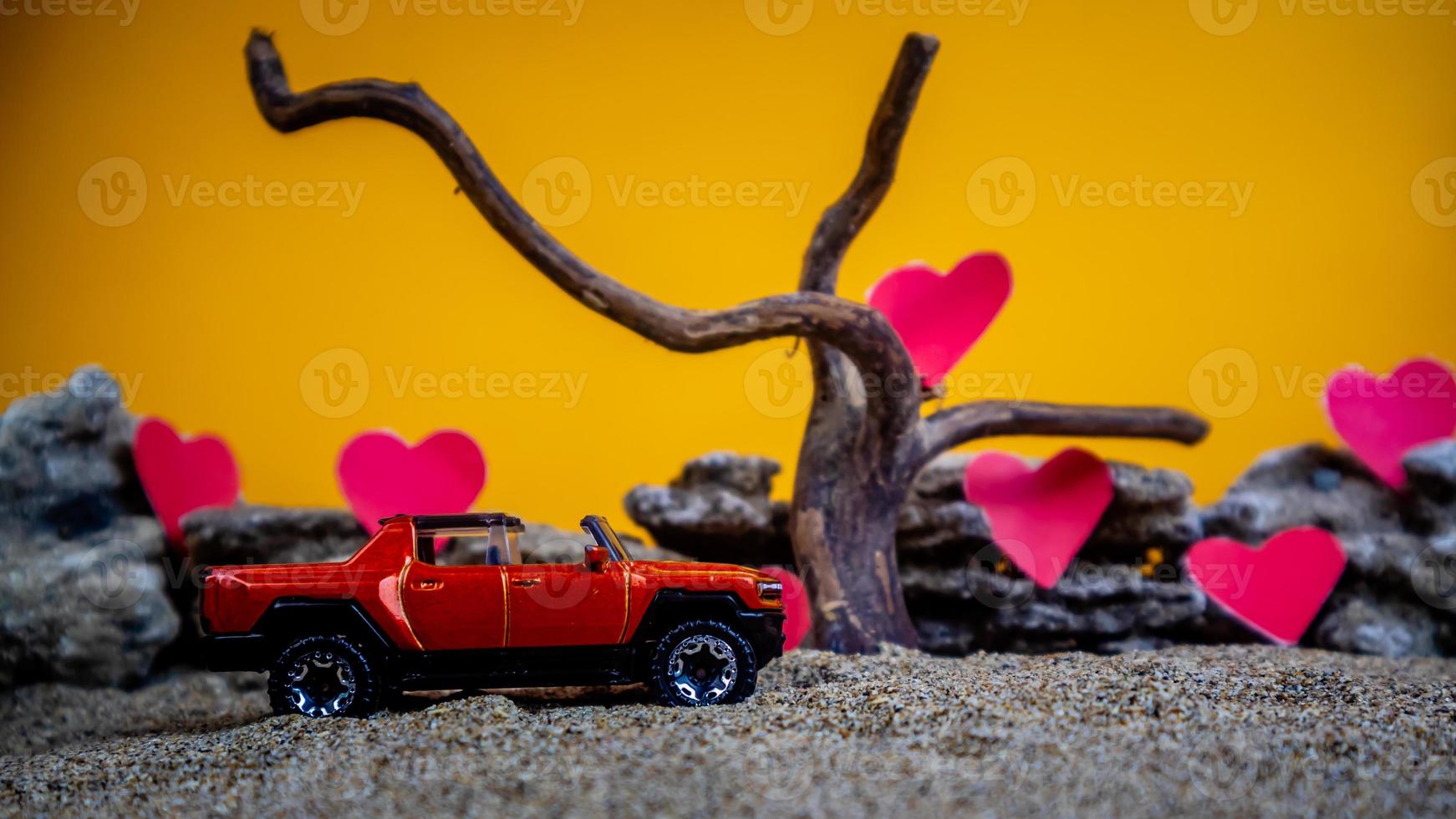 minahasa, indonesia diciembre de 2022, coche de juguete con fondo naranja degradado y corazón foto